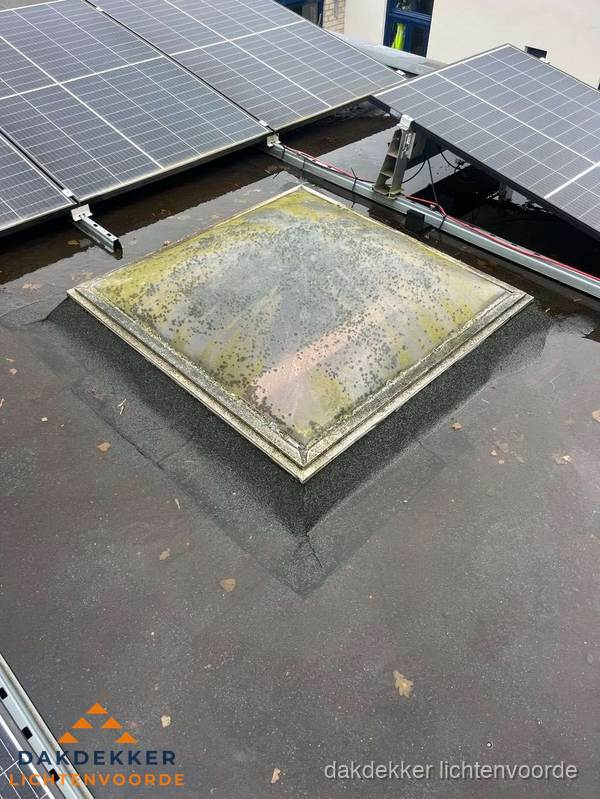 Vervuilde lichtkoepel op plat dak met zonnepanelen in Lichtenvoorde Vervuilde lichtkoepel op plat dak met zonnepanelen in Lichtenvoorde