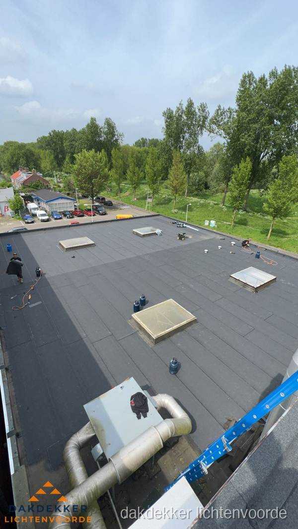 Dakdekker aan het werk op groot plat dak met bitumen in Lichtenvoorde Dakdekker aan het werk op groot plat dak met bitumen in Lichtenvoorde