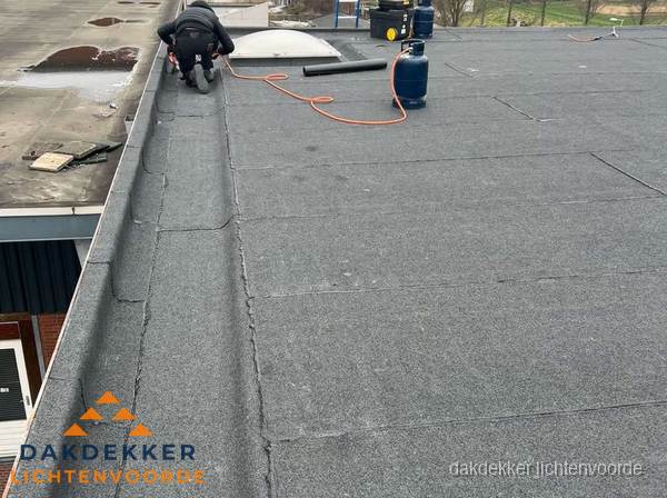 Dakdekker repareert bitumen dakbedekking op groot plat dak in Lichtenvoorde Dakdekker repareert bitumen dakbedekking op groot plat dak in Lichtenvoorde