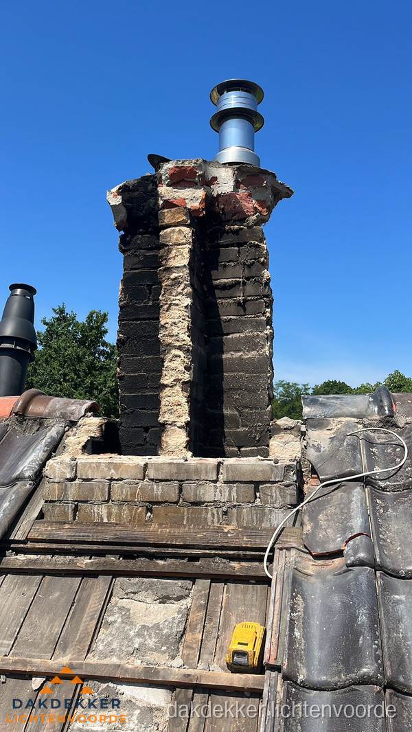 Beschadigde schoorsteen met nieuwe rookgasafvoer op oud dak in Lichtenvoorde Beschadigde schoorsteen met nieuwe rookgasafvoer op oud dak in Lichtenvoorde