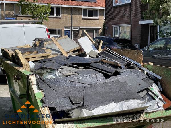 Afvalcontainer met gesloopt dakmateriaal tijdens dakkapel renovatie in Lichtenvoorde Afvalcontainer met gesloopt dakmateriaal tijdens dakkapel renovatie in Lichtenvoorde
