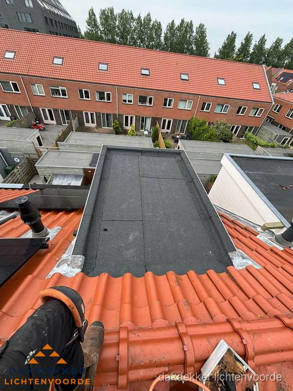 Bitumen dak reparatie op plat dak tussen dakpannen in Lichtenvoorde