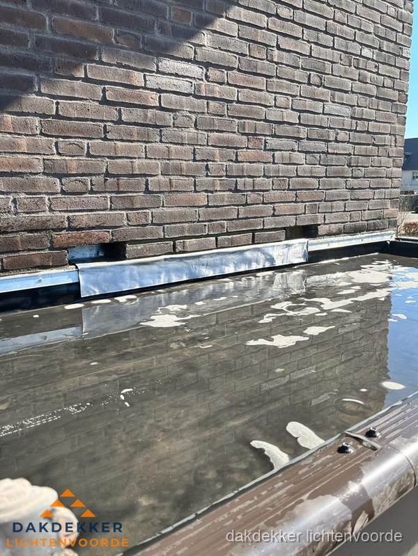 Stilstaand water op plat dak door slechte afwatering in Lichtenvoorde Stilstaand water op plat dak door slechte afwatering in Lichtenvoorde