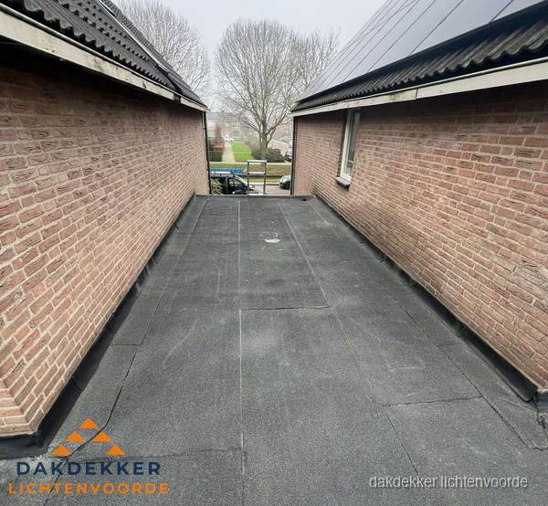 Plat dak met bitumen dakbedekking tussen bakstenen muren in Lichtenvoorde Plat dak met bitumen dakbedekking tussen bakstenen muren in Lichtenvoorde